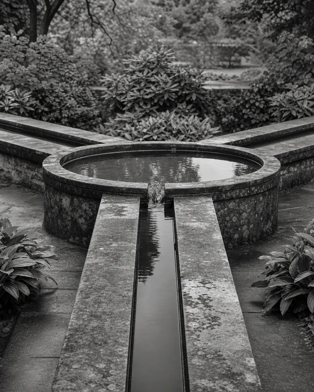 Three water channels feeding into one central stone fountain basin